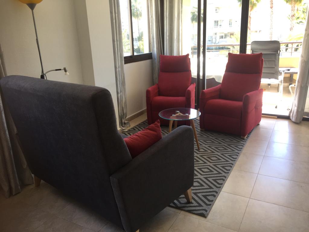 woonkamer met 2 grote zitstoelen en een 2-persoonsbankje